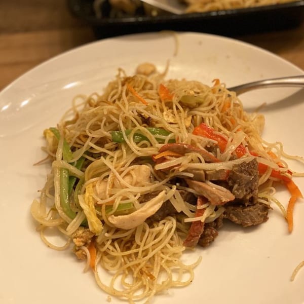 A plate of Japanese-style fried noodles with beef, chicken, and vegetables.
