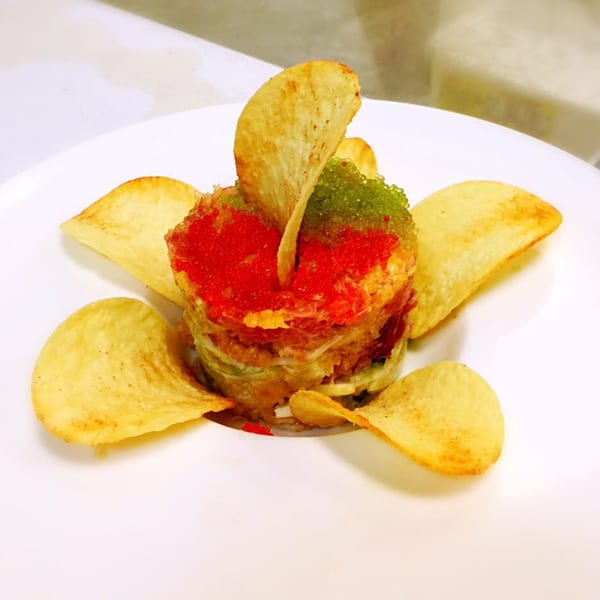 Sushi Joy's colorful Japanese dish with red and green caviar, surrounded by crispy chips on a white plate.